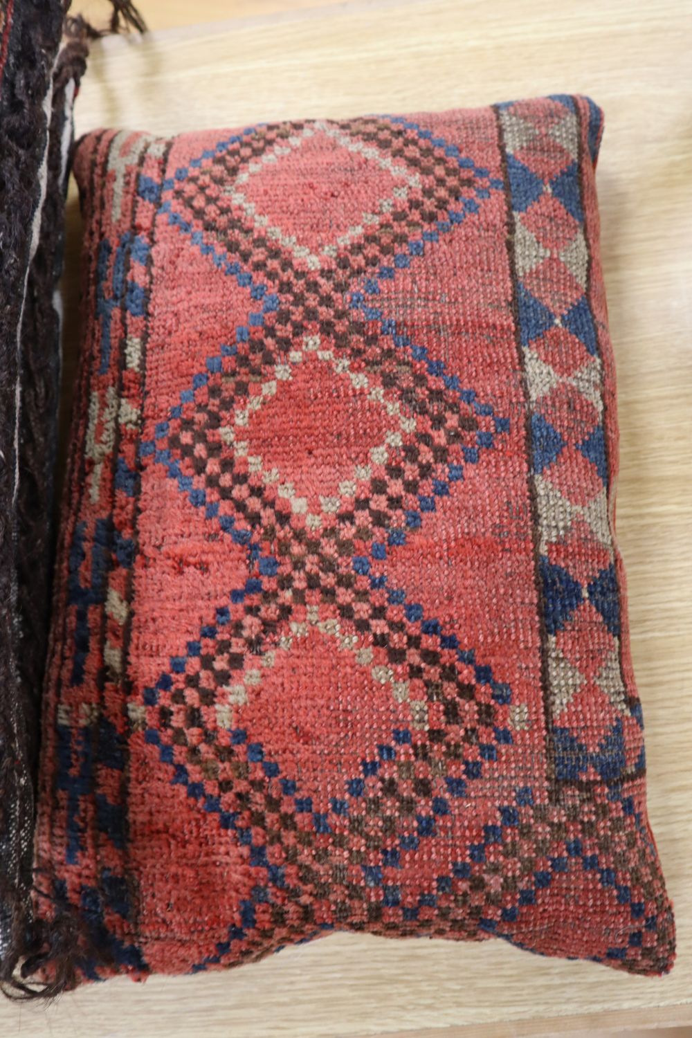 Three carpet cushions, pair 46 x 43cm, single 43 x 28cm